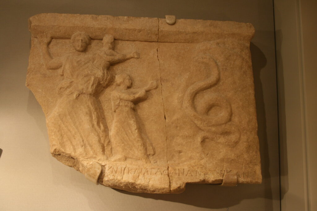 Ancient Greek votive relief, 4th–3rd century BCE, showing Leto fleeing with Apollo and Artemis from the serpent Python.